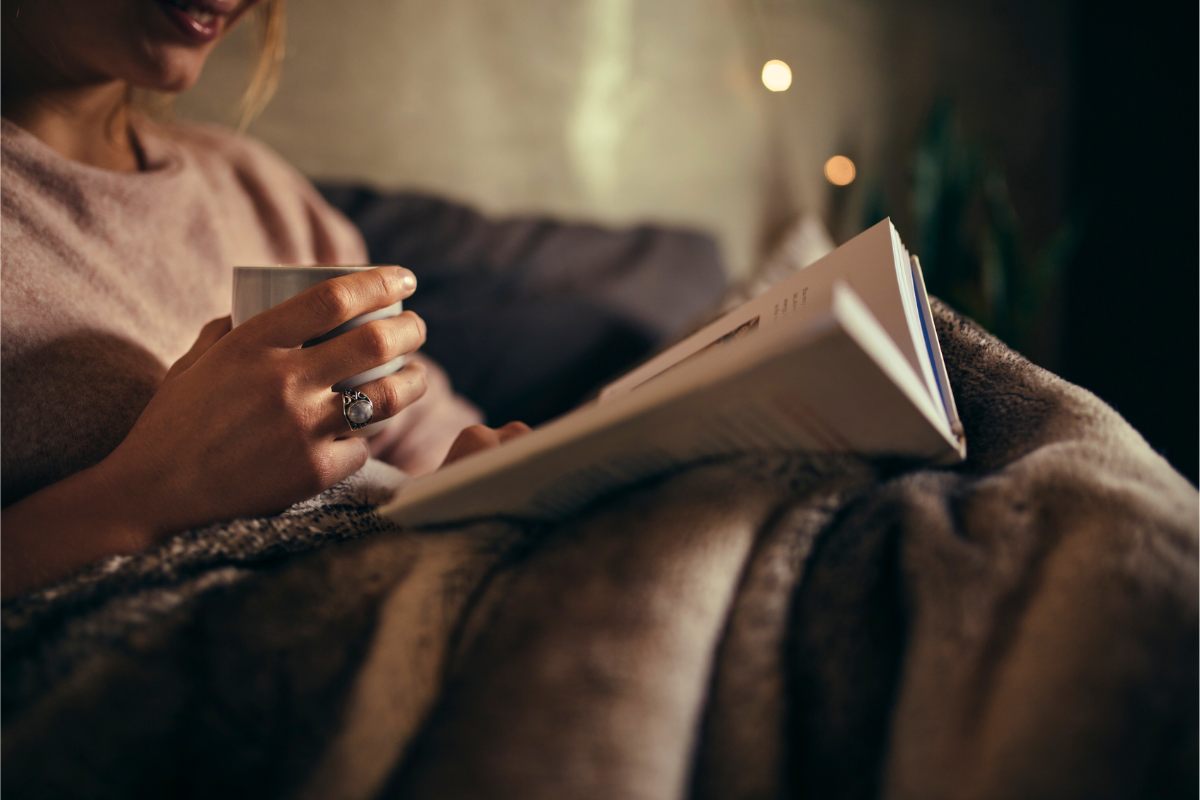 Mujer leyendo un libro en la cama.