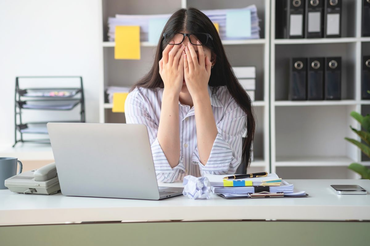 Concepto de síndrome de burnout con una mujer de negocios que se siente incómoda trabajando; el cual es causado por el estrés, acumulado por un trabajo infructuoso y por no descansar lo suficiente.