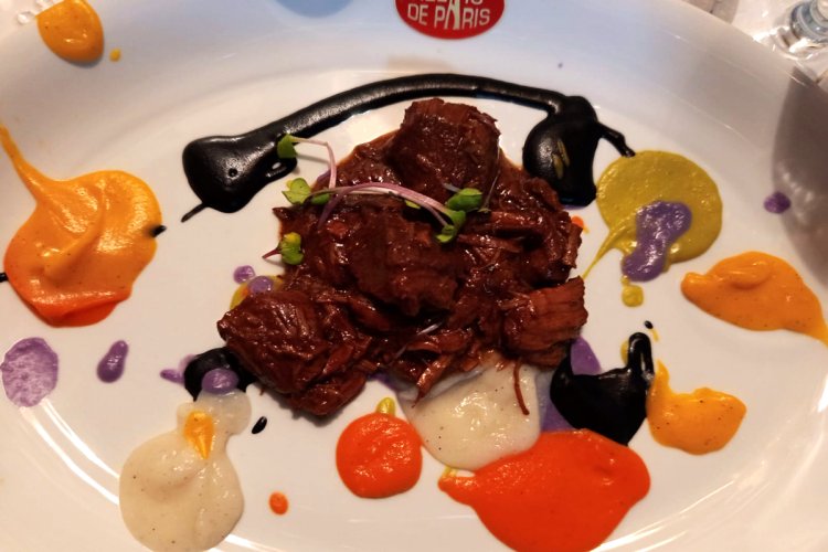 A plate of beef stew with paintings of the chef, by chef Roberto Capone.