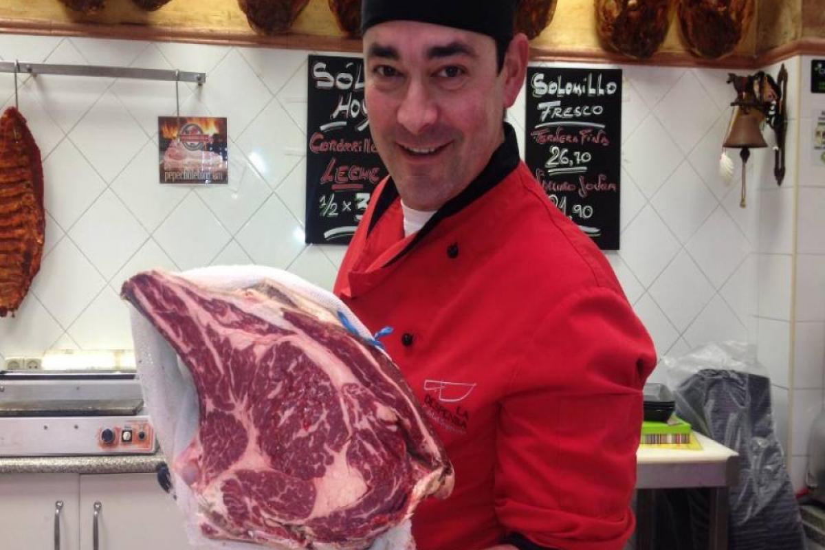 A butcher with a meat sample from Pepe Chuletón.