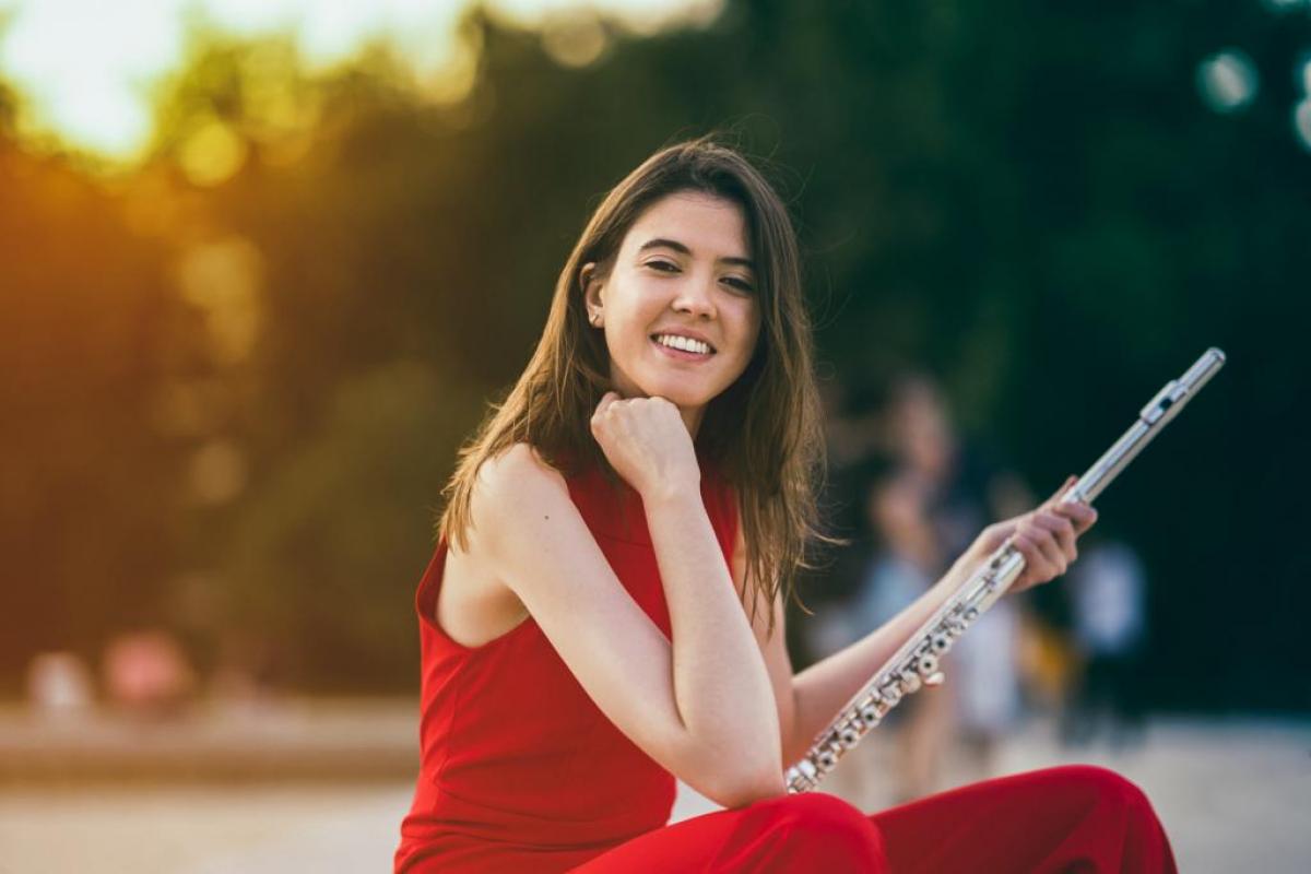 Retrato de Cristina Santirso vestida para un concierto y con su flauta en la mano.